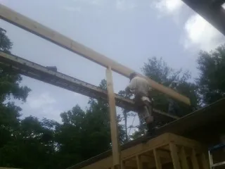 Carpenter setting a ridge beam over a new addition frame — Ice Dam Removal by Roofing Brothers in New Straitsville