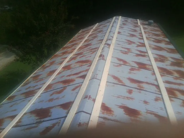 Rusted metal roof panels with new wood purlins before replacement — Storm Damage Roof Repair in New Straitsville by Roofing Brothers