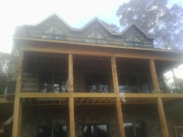 Dormers and porch framing on a large log home under construction — Roof Coating work by our crew in New Straitsville