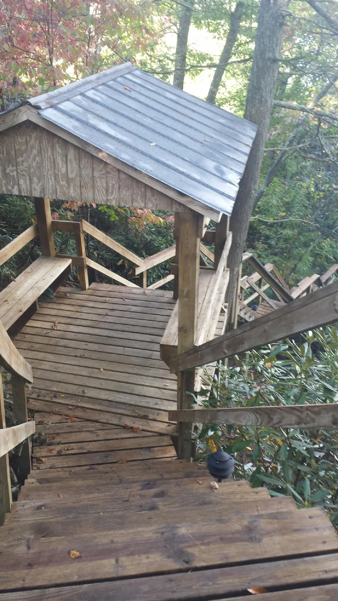 Metal roofed shelter over wooden steps on a wooded walkway — Skylight Repair & Installation work by our crew in New Straitsville
