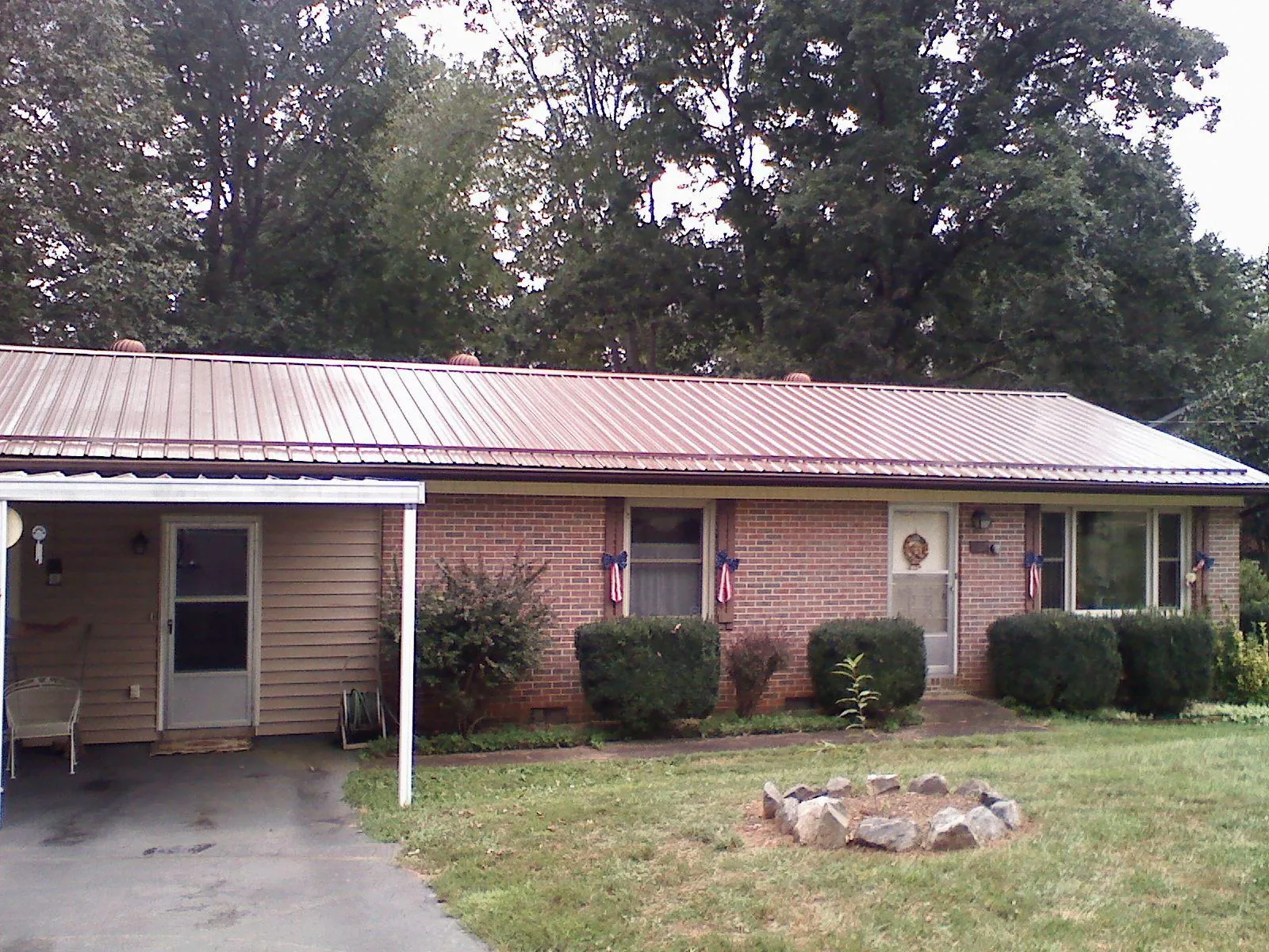Bronze metal roof and carport on a brick ranch home — Roof Repair work by our crew in New Straitsville